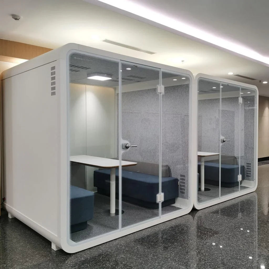An elegantly designed meeting pod, set in a bustling open plan office, embodying innovation and privacy in a modern workspace.