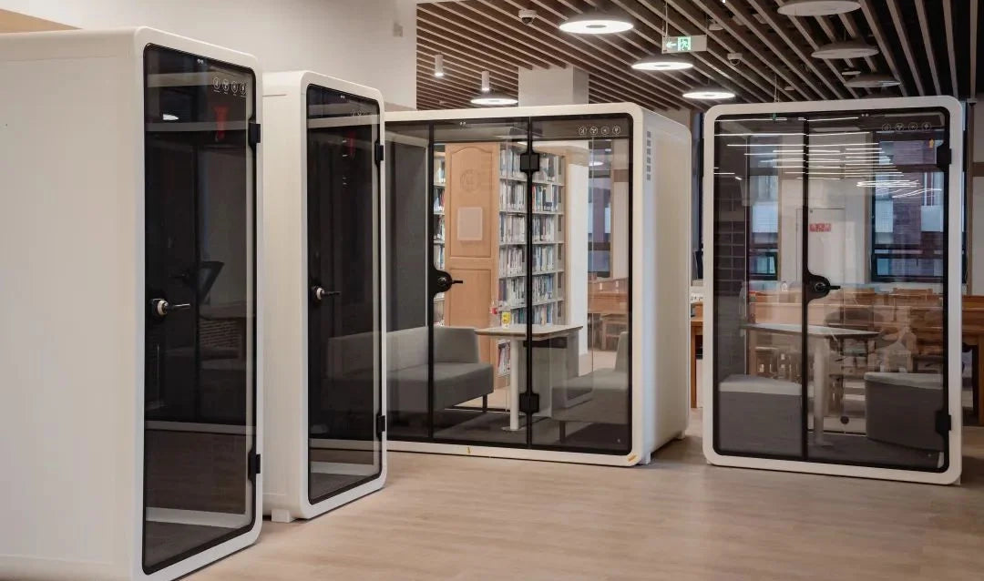 A sleek and modern office pod designed by a Wisconsin startup, nestled in a bustling office environment, symbolizing the perfect blend of privacy and innovation.