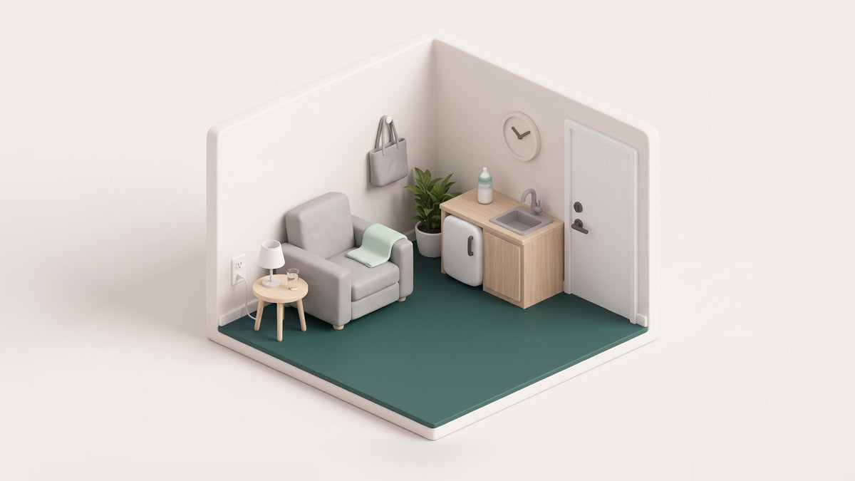 Illustration of a small lactation room seen from above: an armchair with a blanket, a side table with water and a lamp, a sink and small fridge in a wooden counter, a wall clock and a closed door with a lock, on a green floor