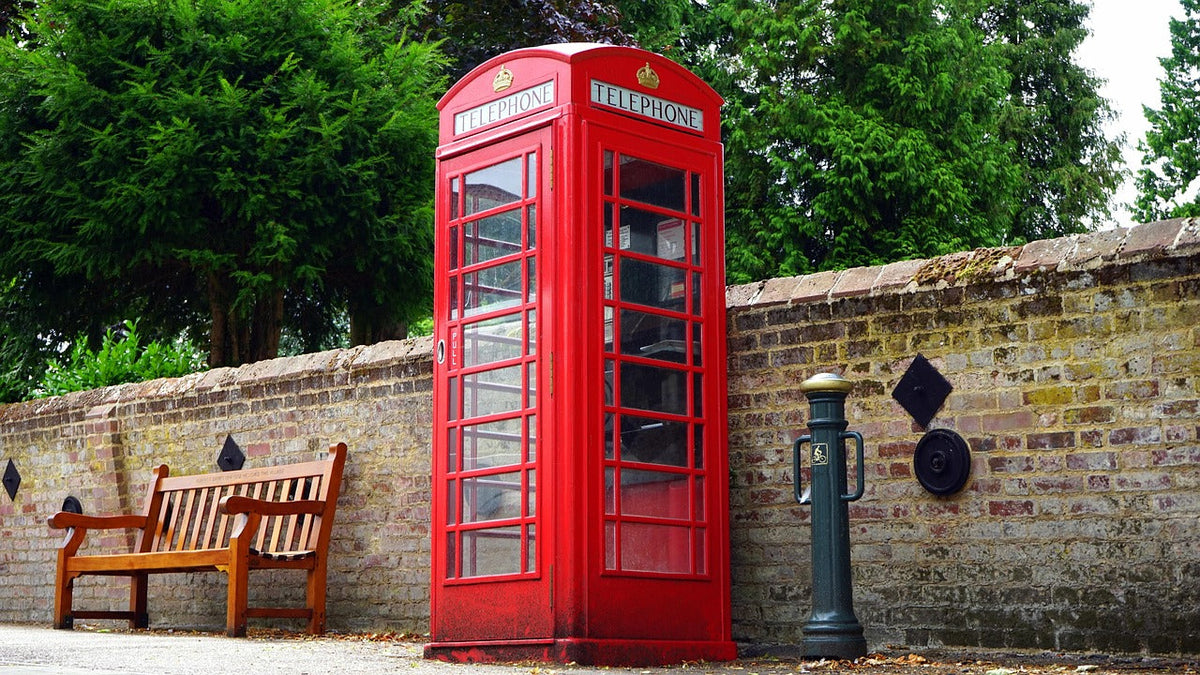 Bright red telephone booth on a sidewalk 