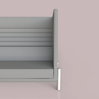 Modern gray sofa with high back on a pink background, featuring a minimalist design and metal legs.