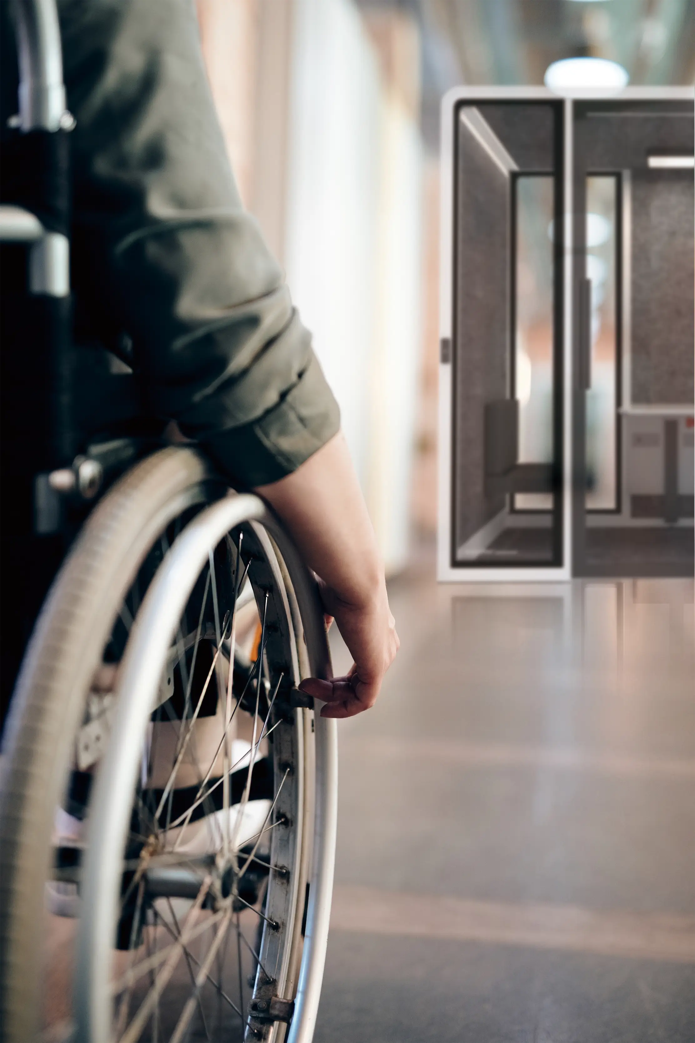 Person in a wheelchair approaching an accessible entrance, highlighting mobility and accessibility.