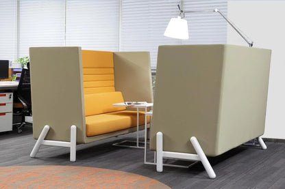 Modern office furniture with privacy seating booth featuring yellow cushions and white lamp in a contemporary workspace.