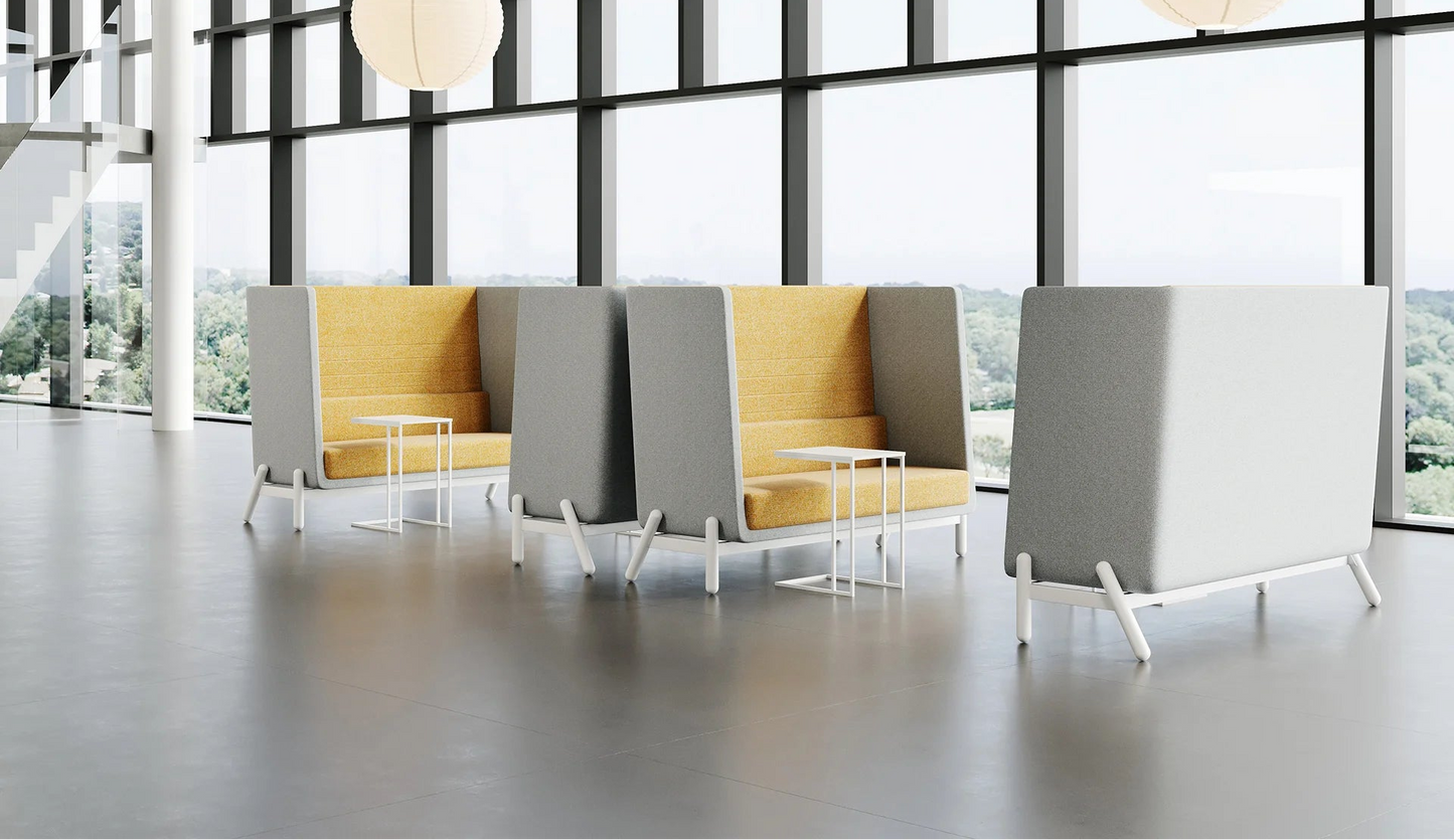 Modern office furniture with gray and yellow chairs in a bright room with large windows.