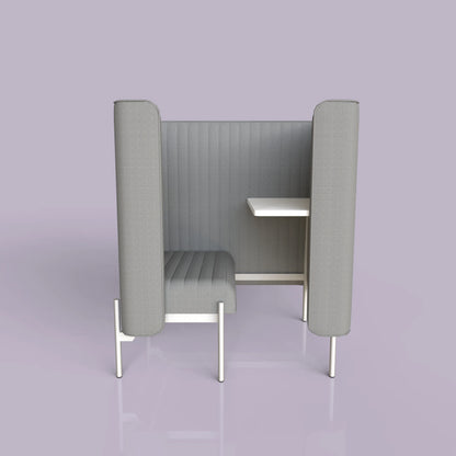 Modern gray privacy booth with padded seating and a small attached desk on a lavender background.