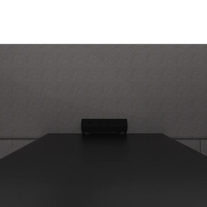 Close-up of the Quad Meeting Nook power module on the table top: two US outlets, USB-A and USB-C against the rear panel